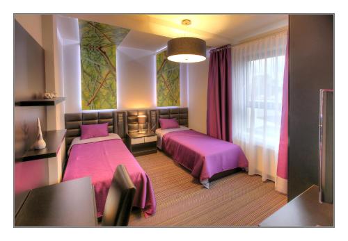a bedroom with two beds and a window with pink sheets at Villa Park in Siedlce