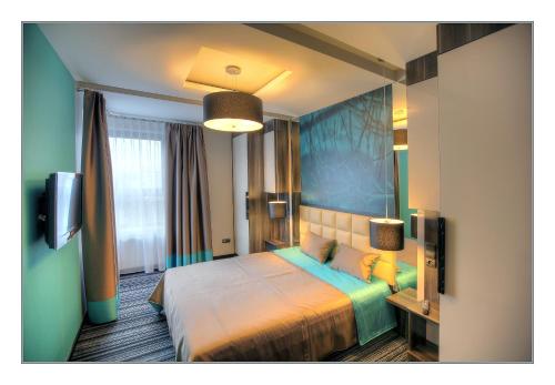 a bedroom with a bed and a tv in it at Villa Park in Siedlce