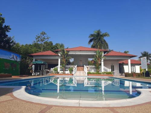 a large swimming pool in front of a house at Cabañas LLano Lindo Apiay in Villavicencio