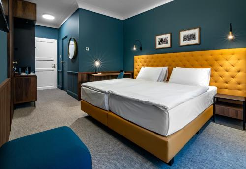 a bedroom with a large bed and blue walls at Palatinus Boutique Hotel in Pécs