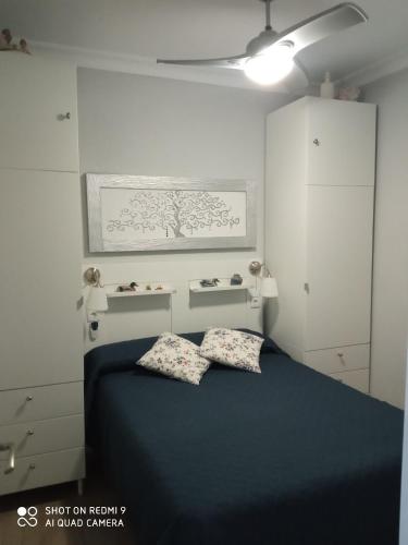 a bedroom with a blue bed with two pillows at Apartamento Solis in Chipiona