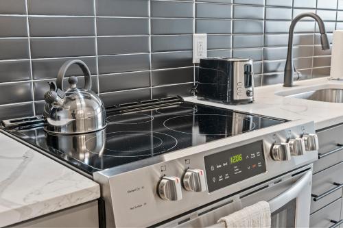a kitchen with a stove with a tea kettle on it at WhyHotel by Placemakr, Columbia in Columbia