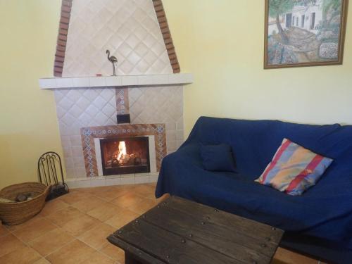 a living room with a blue couch and a fireplace at Casa Launa in Pitres