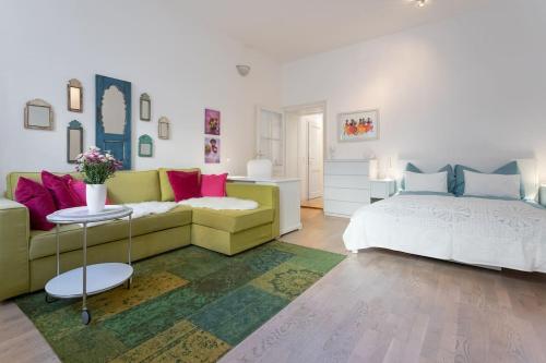 a living room with a couch and a bed at Danube Art Apartments in Vienna