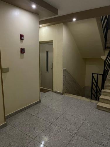 a hallway with stairs and a door in a building at Makkah Hotel in Qena