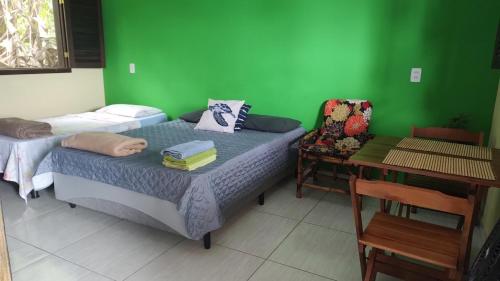 a room with two beds and a green wall at Chalés da Jack in Angra dos Reis