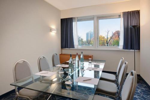 a conference room with a glass table and chairs at Crowne Plaza Milan Linate by IHG in San Donato Milanese