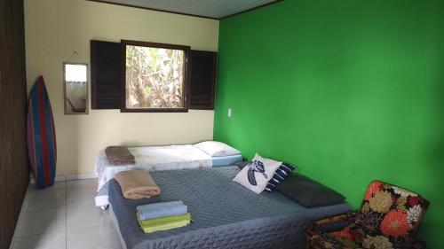 a room with a couch and a green wall at Chalés da Jack in Angra dos Reis