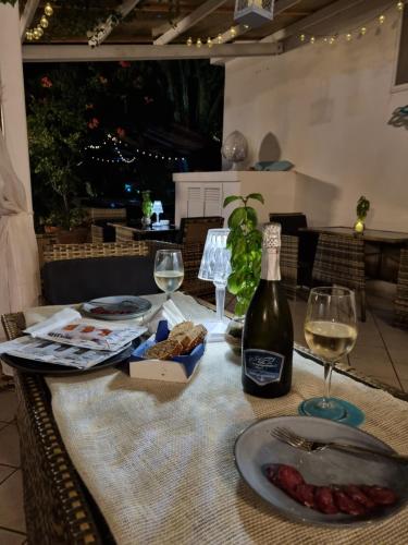 a table with a bottle of wine and wine glasses at Villa Bina Sea Hotel in Ischia