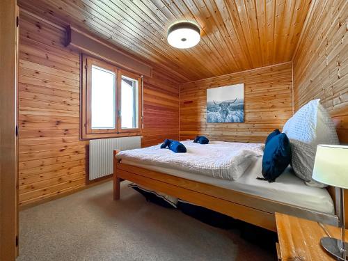 ein Schlafzimmer mit einem Bett in einer Holzhütte in der Unterkunft Mirador Lodge - Crans Montana - Swiss Alps in Crans-Montana