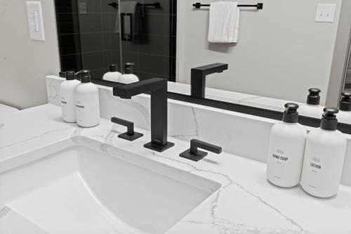 a bathroom with a sink and four bottles of soap at WhyHotel by Placemakr, Columbia in Columbia
