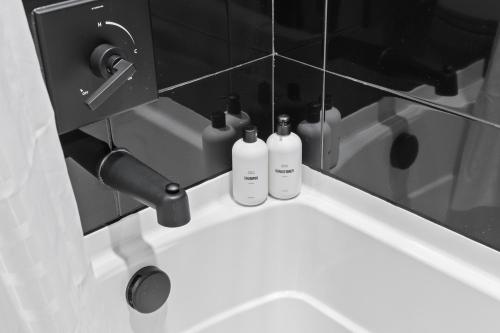 two bottles sitting on a sink in a bathroom at WhyHotel by Placemakr, Columbia in Columbia