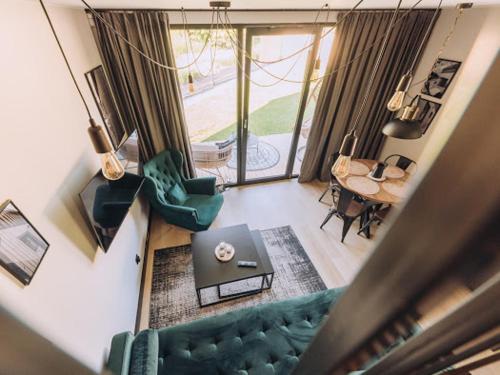 a living room with a green couch and a table at Między Brzozami in Szczytna