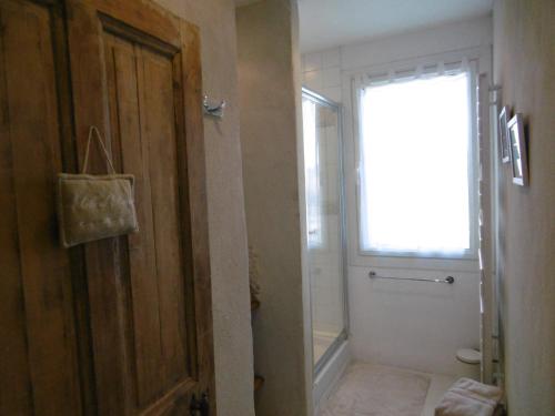 a bathroom with a toilet and a window and a door at Le petit mas en provence avec piscine in Barbentane