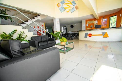 uma sala de estar com um sofá e uma escada em Hotel Piramide Pituba - Av Paulo VI em Salvador