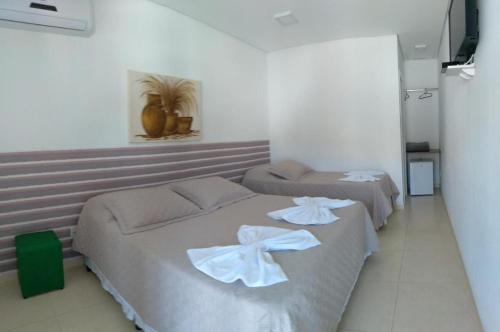 a bedroom with two beds with white towels on them at Pousada Aconchego dos Gerânios in Paraty