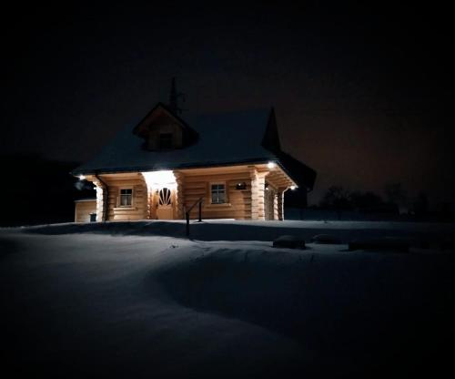 a church lit up at night in the snow at Dom z bala in Lipowa