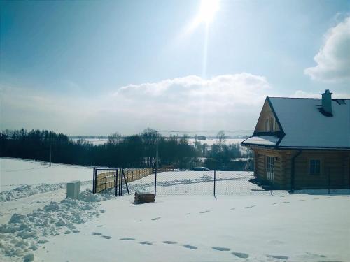 a house in the snow next to a fence at Dom z bala in Lipowa