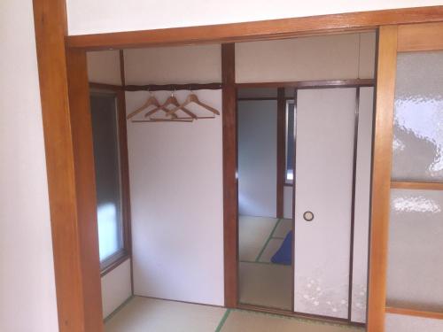 D-pdal Inn - Vacation STAY 38493v في طوكيو: غرفة مع خزانة مع باب زجاجي