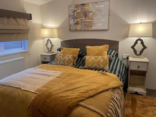 a bedroom with a large bed with yellow pillows at Ravenwood Lodge in Dollar