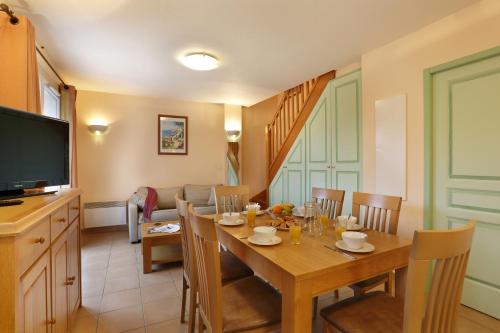 a dining room with a table and a television at Vacancéole - Les Bastides de Fayence in Tourrettes
