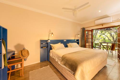 a bedroom with a bed and a table and a window at Sedia Riverside Hotel in Maun