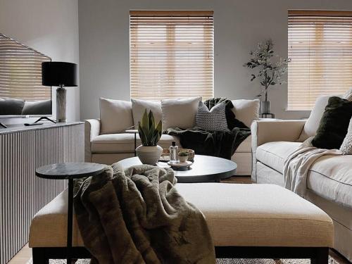 uma sala de estar com sofás, uma mesa e um sofá em Modern Ground Floor Apartment em Todmorden