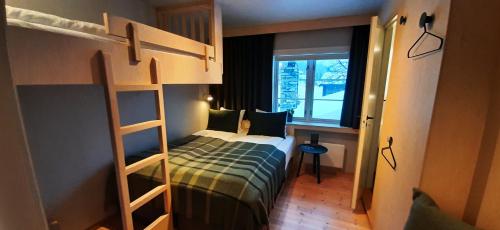 a small bedroom with a bunk bed and a window at Rondane River Lodge - Rondane Gjestegård in Enden