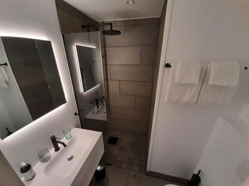 a white bathroom with a sink and a shower at Rondane River Lodge - Rondane Gjestegård in Enden