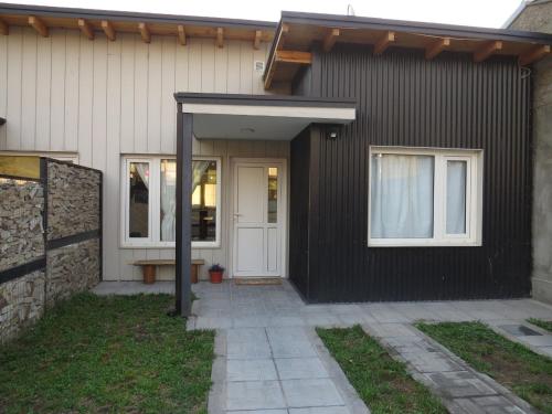 a black house with a white door and windows at Casa Nera in Esquel