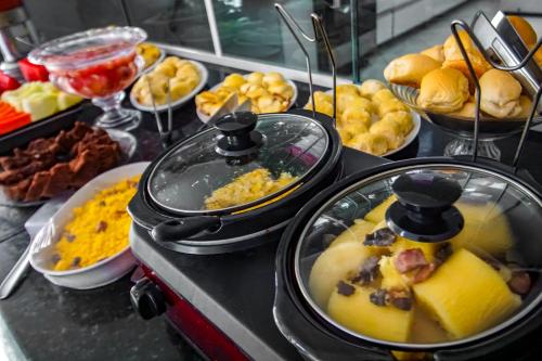 ein Buffet mit verschiedenen Speisen auf einem Tisch in der Unterkunft Hotel Piramide Pituba - Rua Pernambuco in Salvador