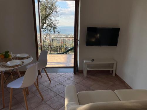 ein Wohnzimmer mit einem Sofa, einem Tisch und einem TV in der Unterkunft SKY VIEW Villa in Piano di Sorrento