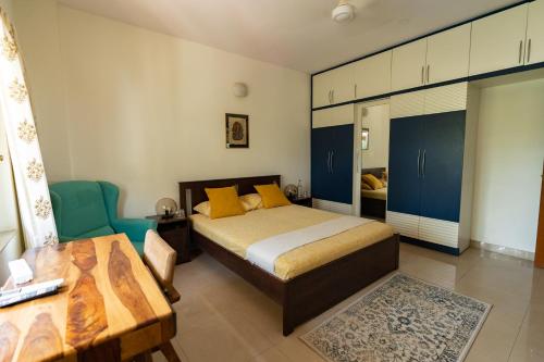 a bedroom with a bed and a table and blue cabinets at Luho 206 in Bangalore