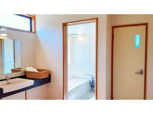 W łazience znajduje się umywalka, wanna i lustro. w obiekcie Sudomari no Yado Sunmore - Vacation STAY 46734v w mieście Nikko