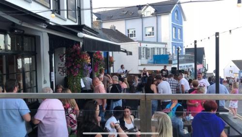 a crowd of people standing outside of a restaurant at Hotel Penwig in New Quay