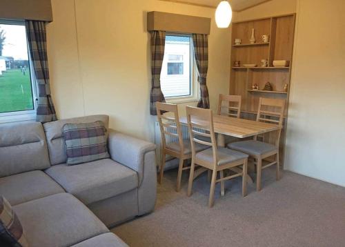 a living room with a couch and a table and chairs at Tollerton Holiday Park in Huby