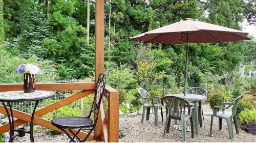 a patio with tables and chairs and an umbrella at Sudomari no Yado Sunmore - Vacation STAY 46722v in Nikko