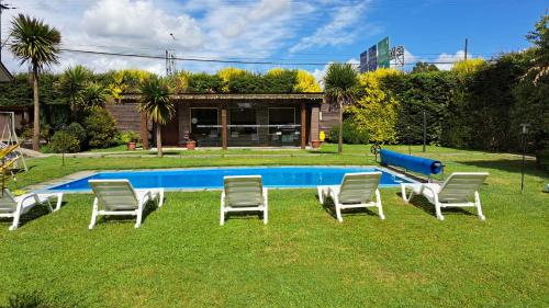 un grupo de sillas y una piscina en Hosteria y Cabañas Rucantu en Freire