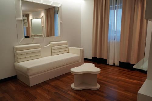 a white dressing room with a mirror and a stool at Residence Prestige in Gorgonzola