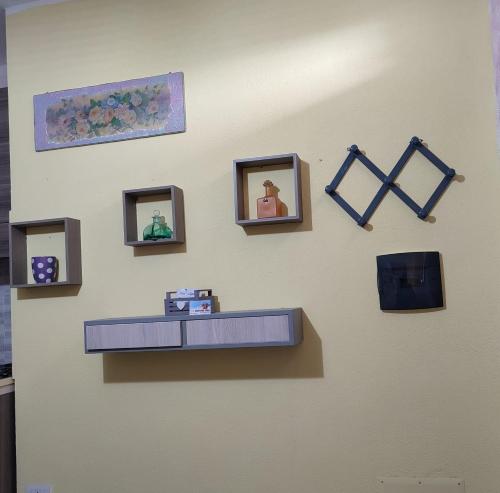 a wall with a shelf and pictures on a wall at Holiday Sun in Badesi