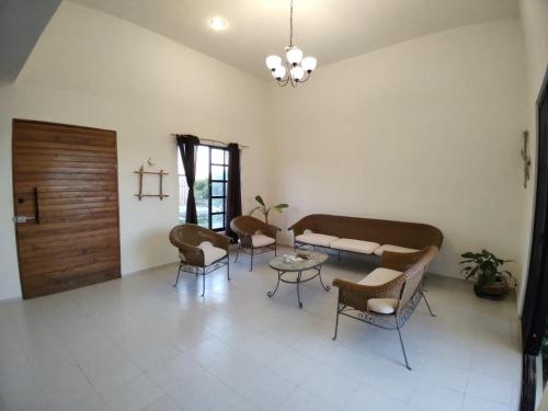 uma sala de estar com um sofá, cadeiras e uma mesa em Casa Calandria em Chicxulub