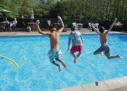 three young boys jumping into a swimming pool at Notter Mill in Landrake