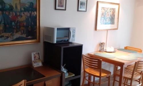 a room with a desk and a table with a microwave at Hegyesi Vendégház in Gödöllő