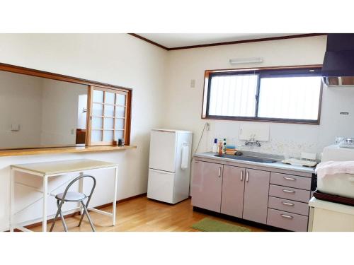 La cuisine est équipée d'un réfrigérateur blanc et d'un évier. dans l'établissement Sudomari no Yado Sunmore - Vacation STAY 46754v, à Nikkō