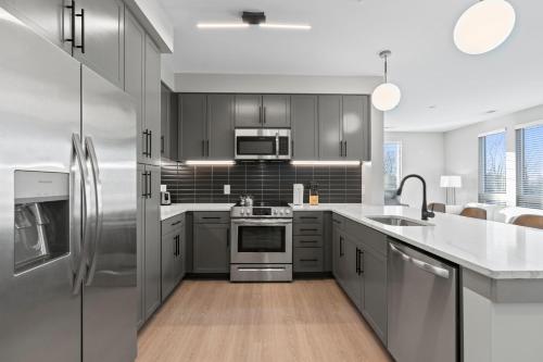a kitchen with gray cabinets and stainless steel appliances at WhyHotel by Placemakr, Columbia in Columbia