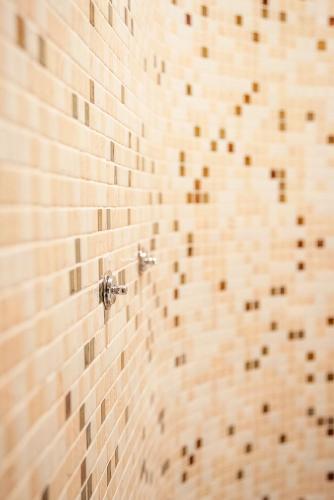 a bathroom with a tiled wall with a shower at Bosque de Xarás, casa completa con encanto cerca de playa de Lapamán in Marín