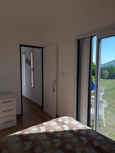 a bedroom with a bed and a sliding glass door at Las Golondrinas Container in Mar del Plata
