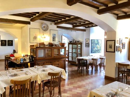 un ristorante con tavoli e sedie in una stanza di Hotel Trattoria Pallotta ad Assisi