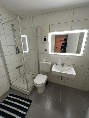 ein Badezimmer mit einem WC, einem Waschbecken und einem Spiegel in der Unterkunft Zentral gelegene Apartments in Gelsenkirchen für bis zu 5 Personen in Gelsenkirchen