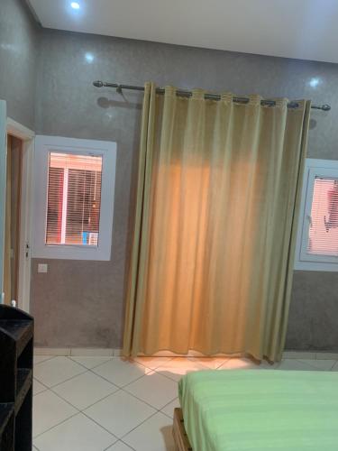 a bedroom with a bed and a curtain at Europa mirlef t aventur Guest House in Mirleft